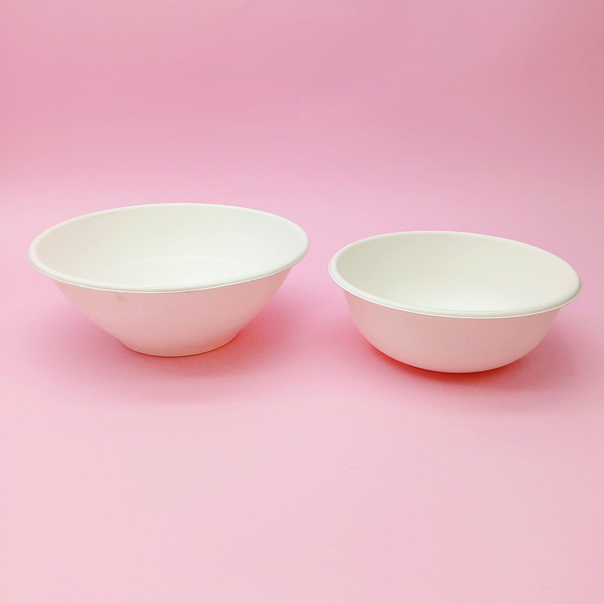 Ciotole bianche bio di due dimensioni diverse, su sfondo rosa