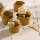 Coppette per gelato color avana. Alcune impilate, due riempite di gelato di cui una chiusa con cupola di plastica