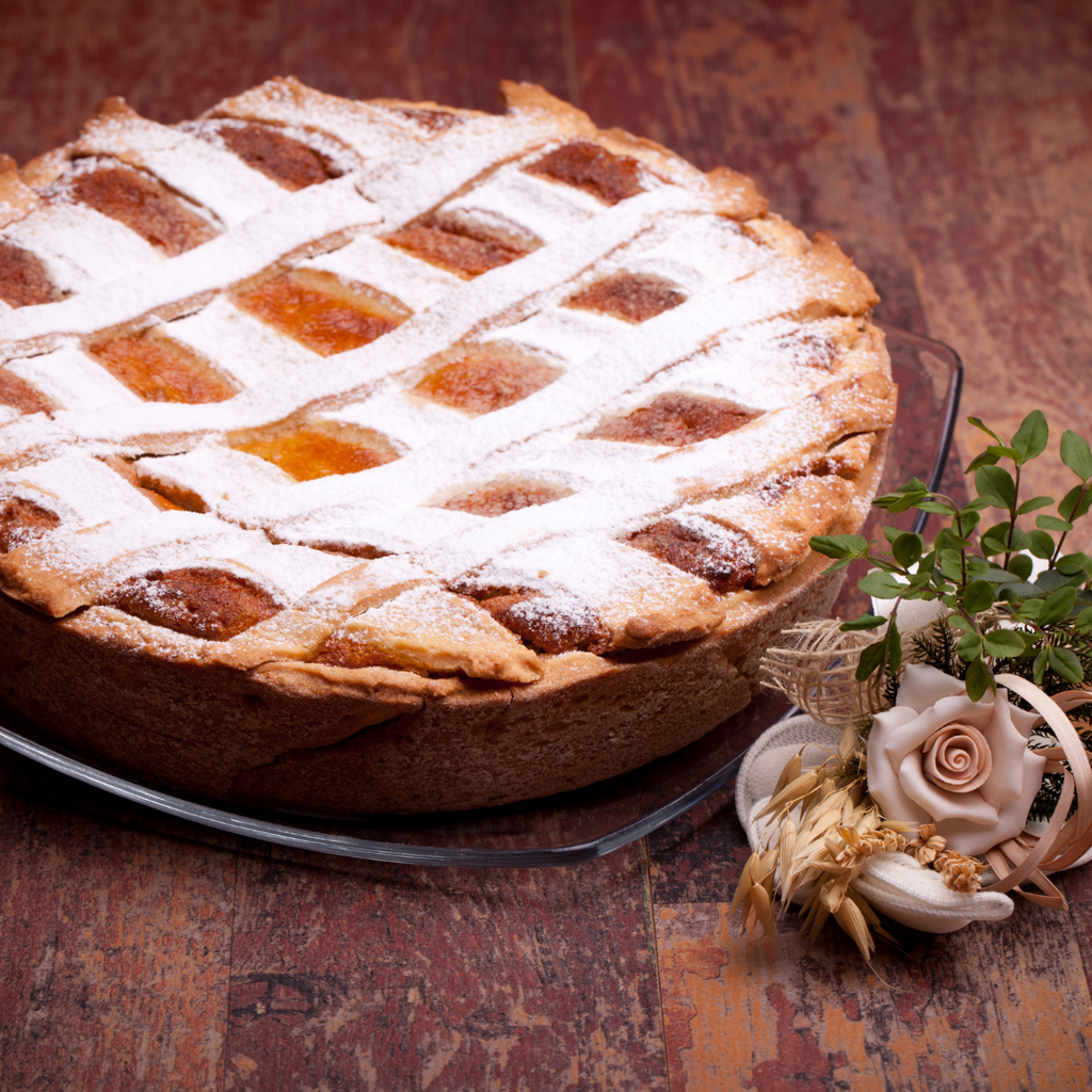 Pastiera su tavolo vicino a composizione floreale