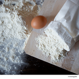Dettaglio di uovo, farine e tagliere