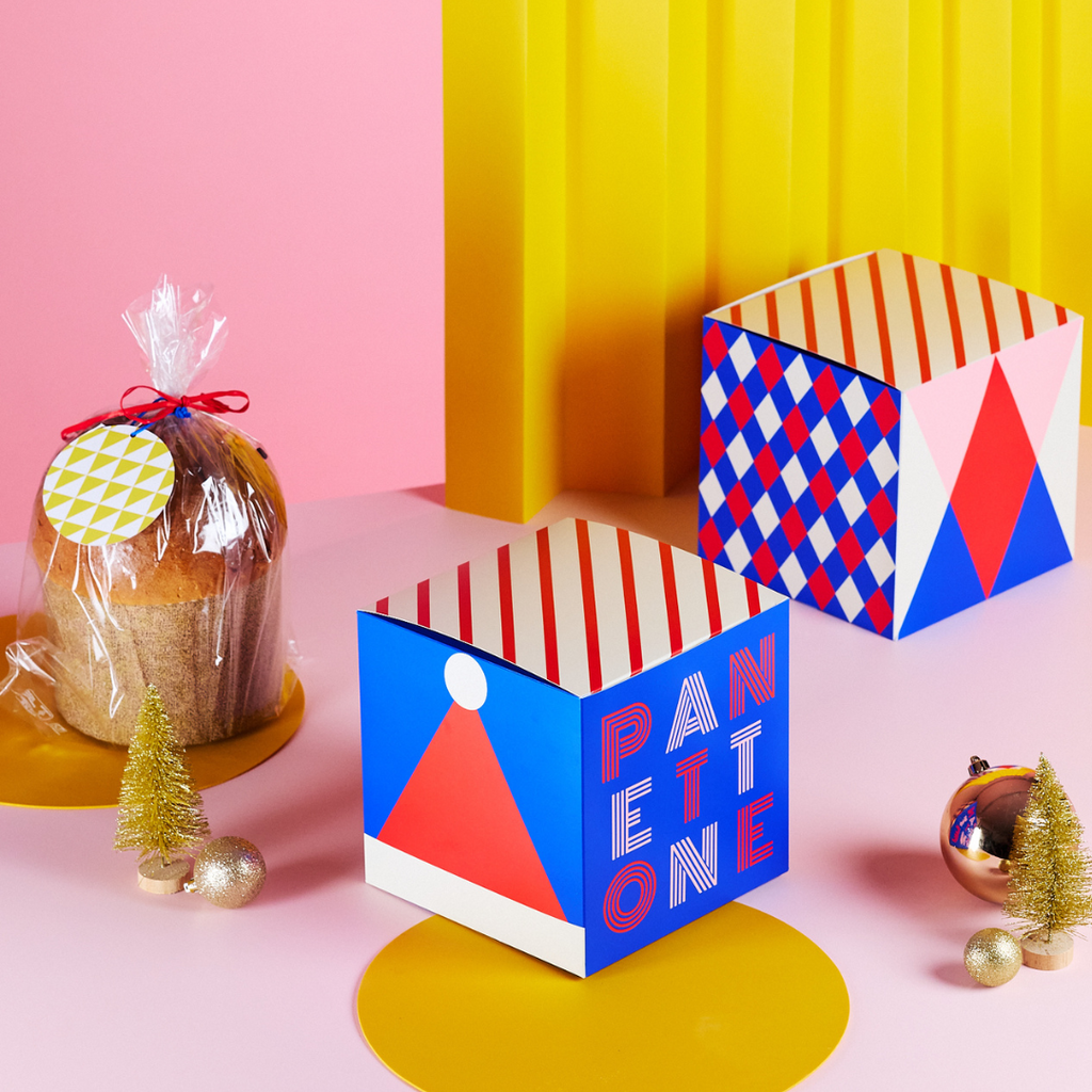 Scatole panettone circus tra elementi natalizi