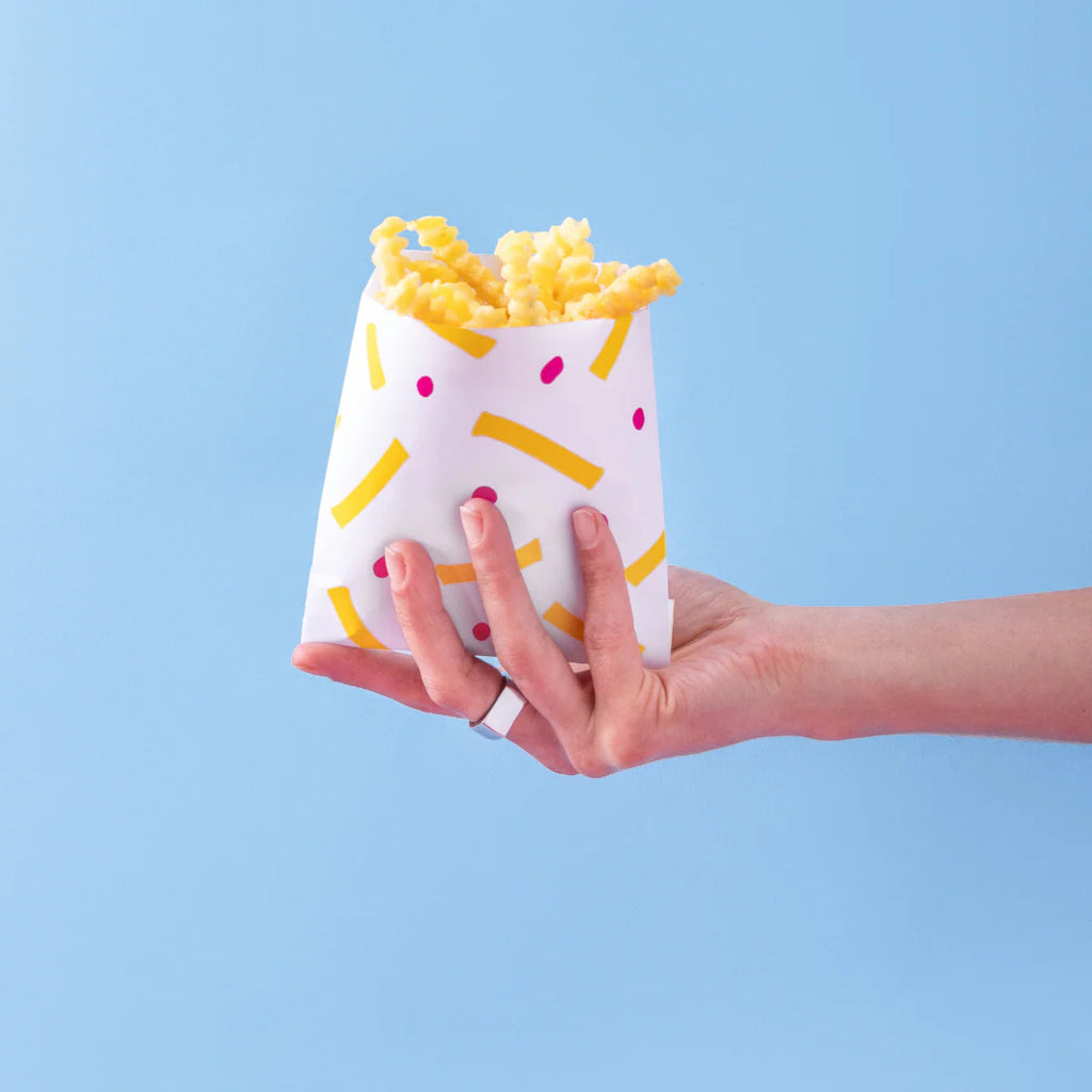 Mano che tiene un sacchetto con patatine fritte