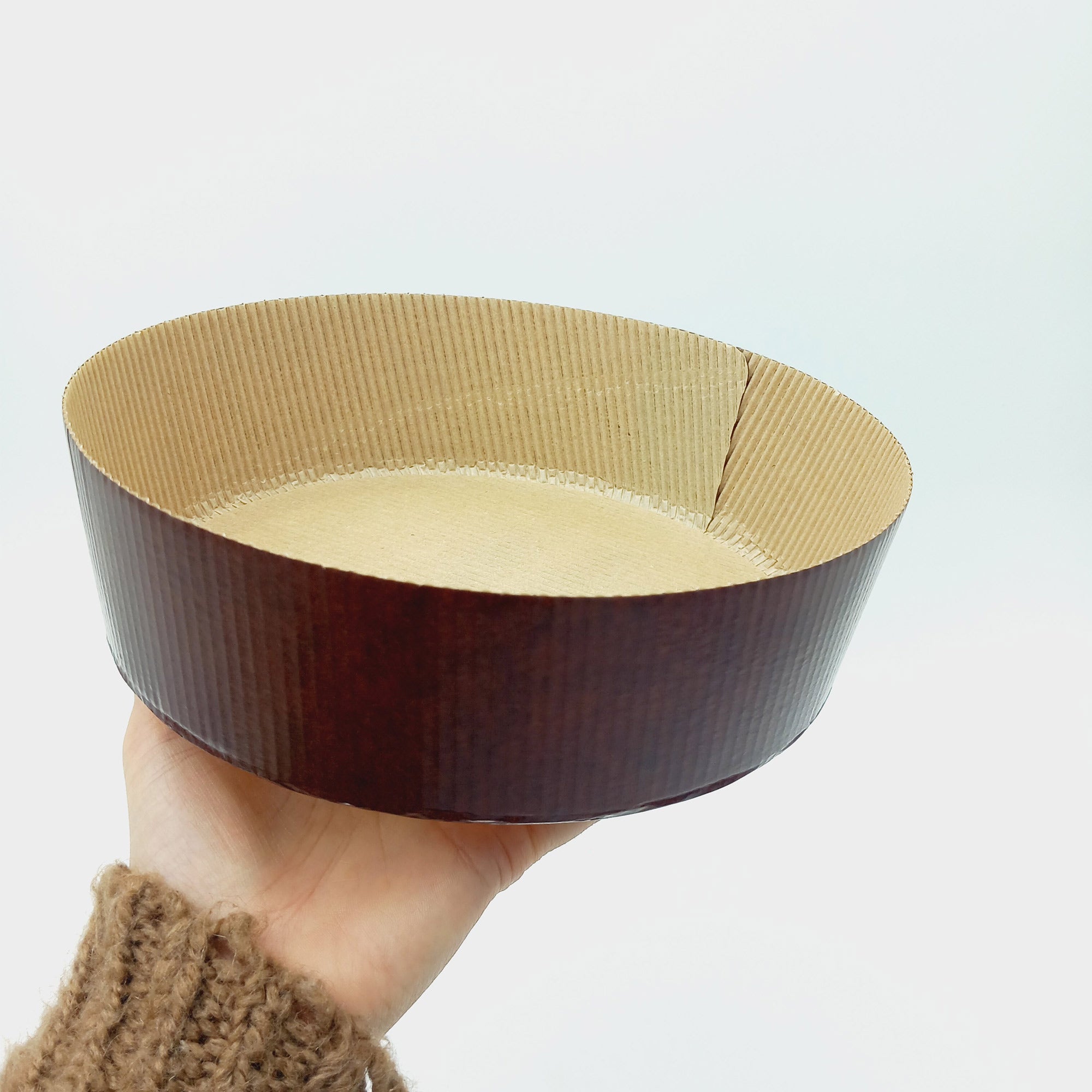 Stampo per panettone basso, vuoto retto da una mano