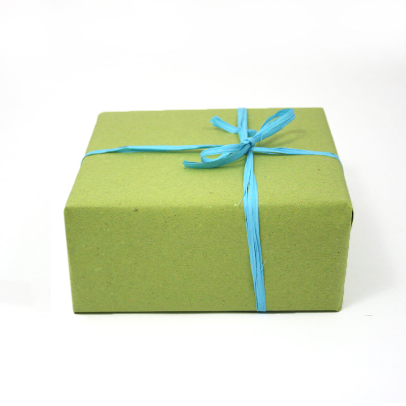 Regalo incartato con carta paglia verde e nastro azzurro