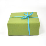 Regalo incartato con carta paglia verde e nastro azzurro