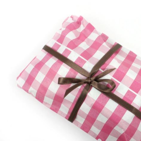 Vassoio avvolto da carta a scacchi bianchi e rosa e fiocco marrone