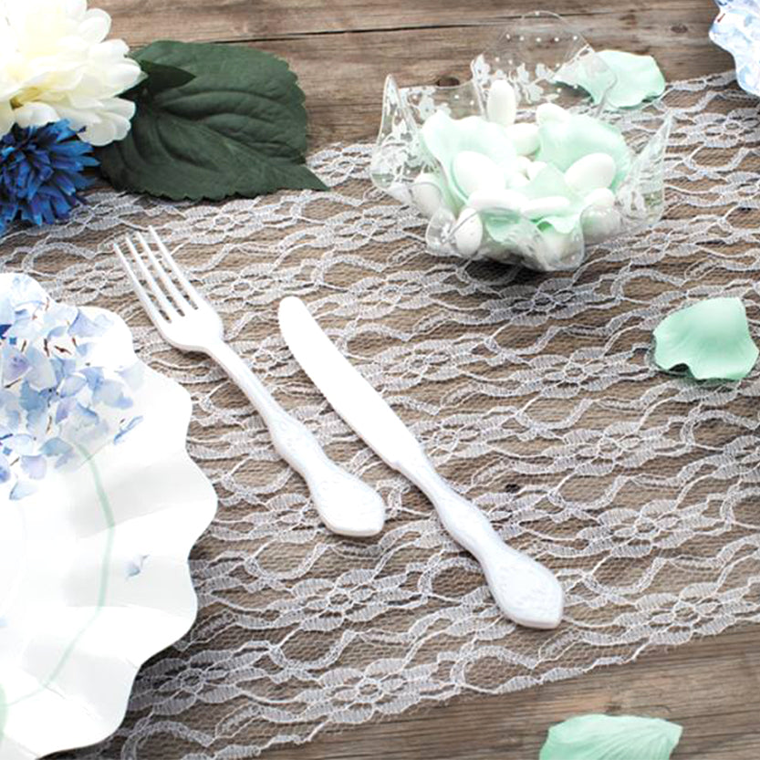 Posate bianche di plastica su tovagliato di pizzo