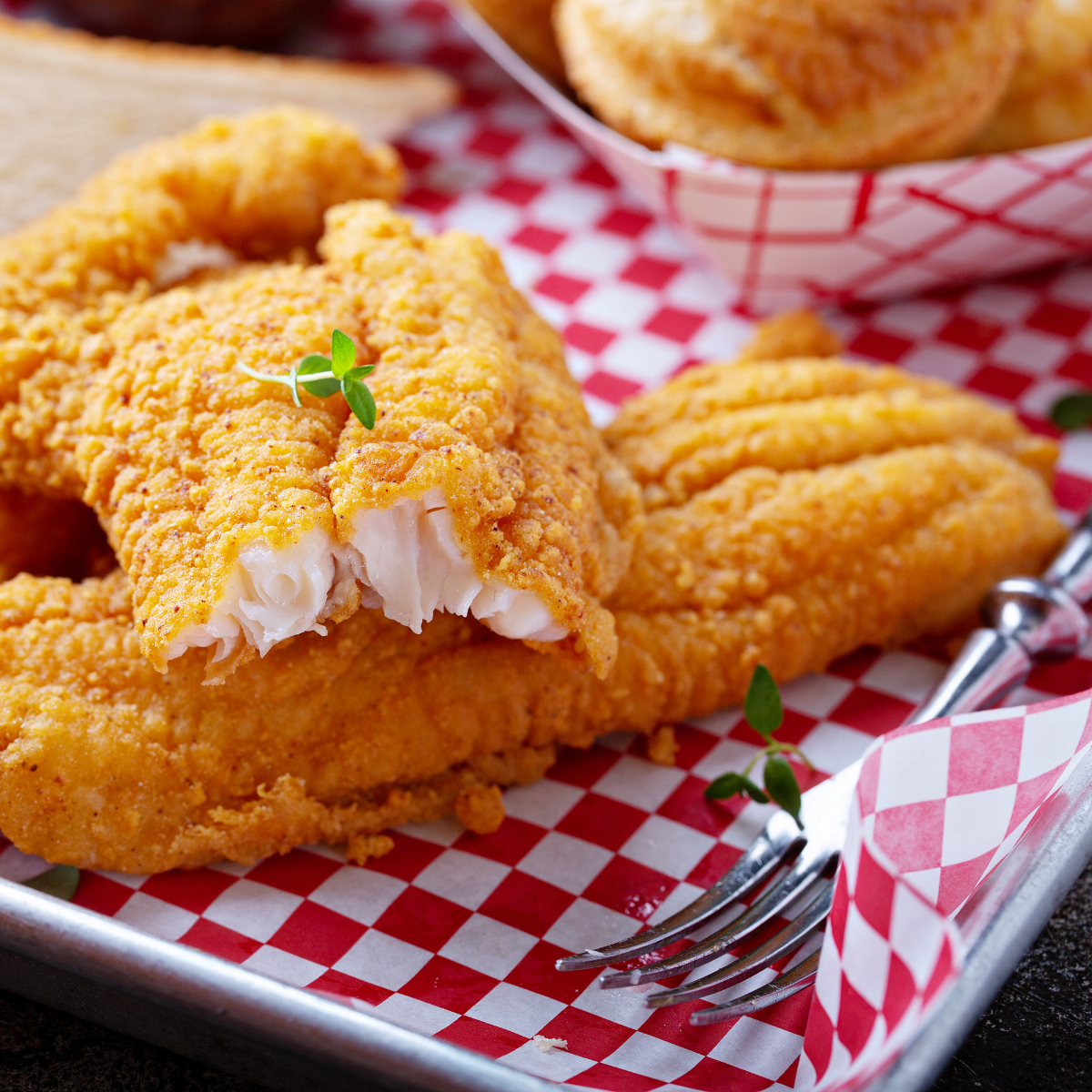 Dettaglio di pesce fritto su carta alimenti a quadretti bianchi e rossi 