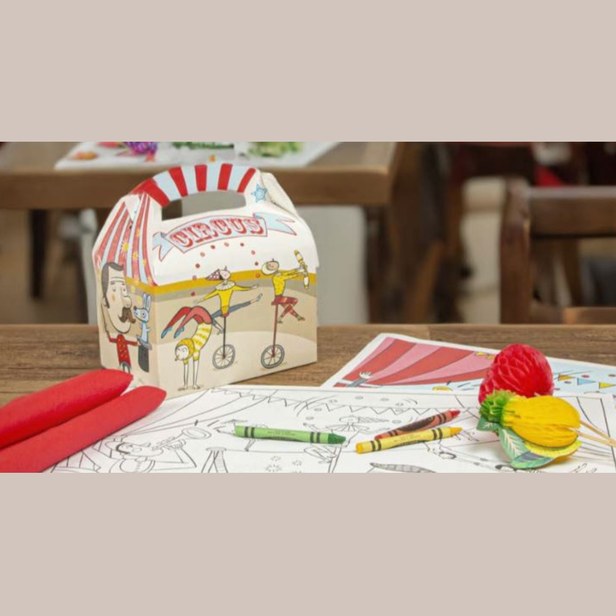 Scatola porta pranzo fantasia circo su tavola con tovagliette da colorare pastelli e festoni