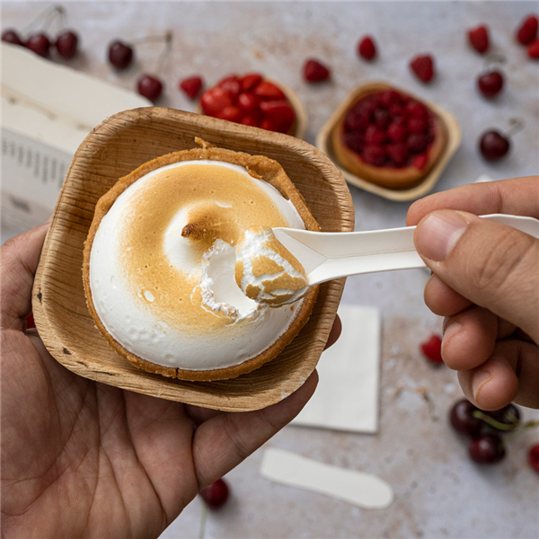 Mani che da una ciotolina mangiano un dolce con un cucchiaino 