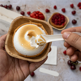 Mani che da una ciotolina mangiano un dolce con un cucchiaino 