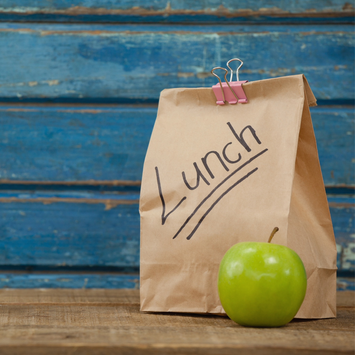 Sacchetto di carta per lunch con vicino una mela verde 