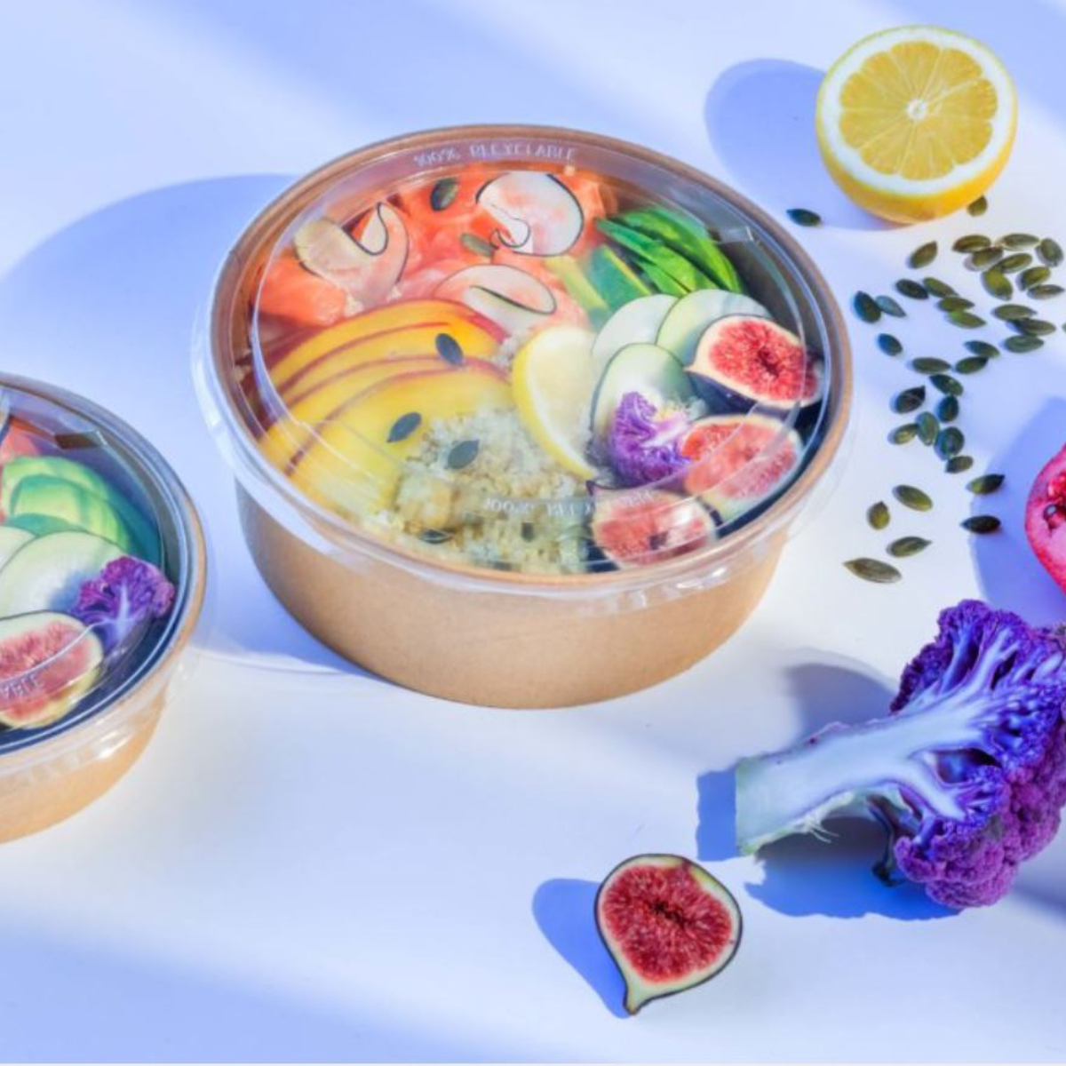 Confezione avana con coperchio trasparente piena di pokè su tavola 