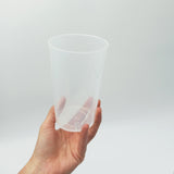 Bicchiere di plastica riutilizzabile retto da una mano