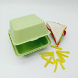 Porta merenda verde chiuso visto  aperto ocn accanto patatine fritte ed un sandwich