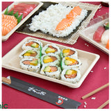 Piatti di sushi con sushi su tavolo roso in cui ci sono bacchette e sushi su altri piatti 