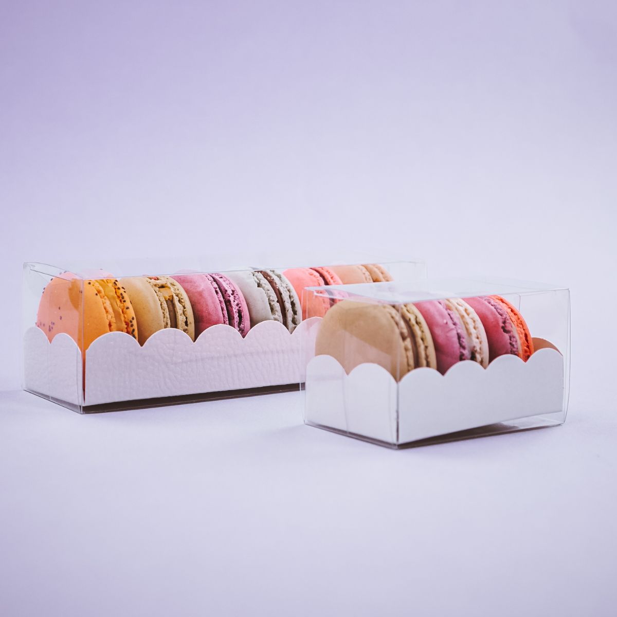 Due scatole di macarons trasparenti, piene, di due misure diverse 