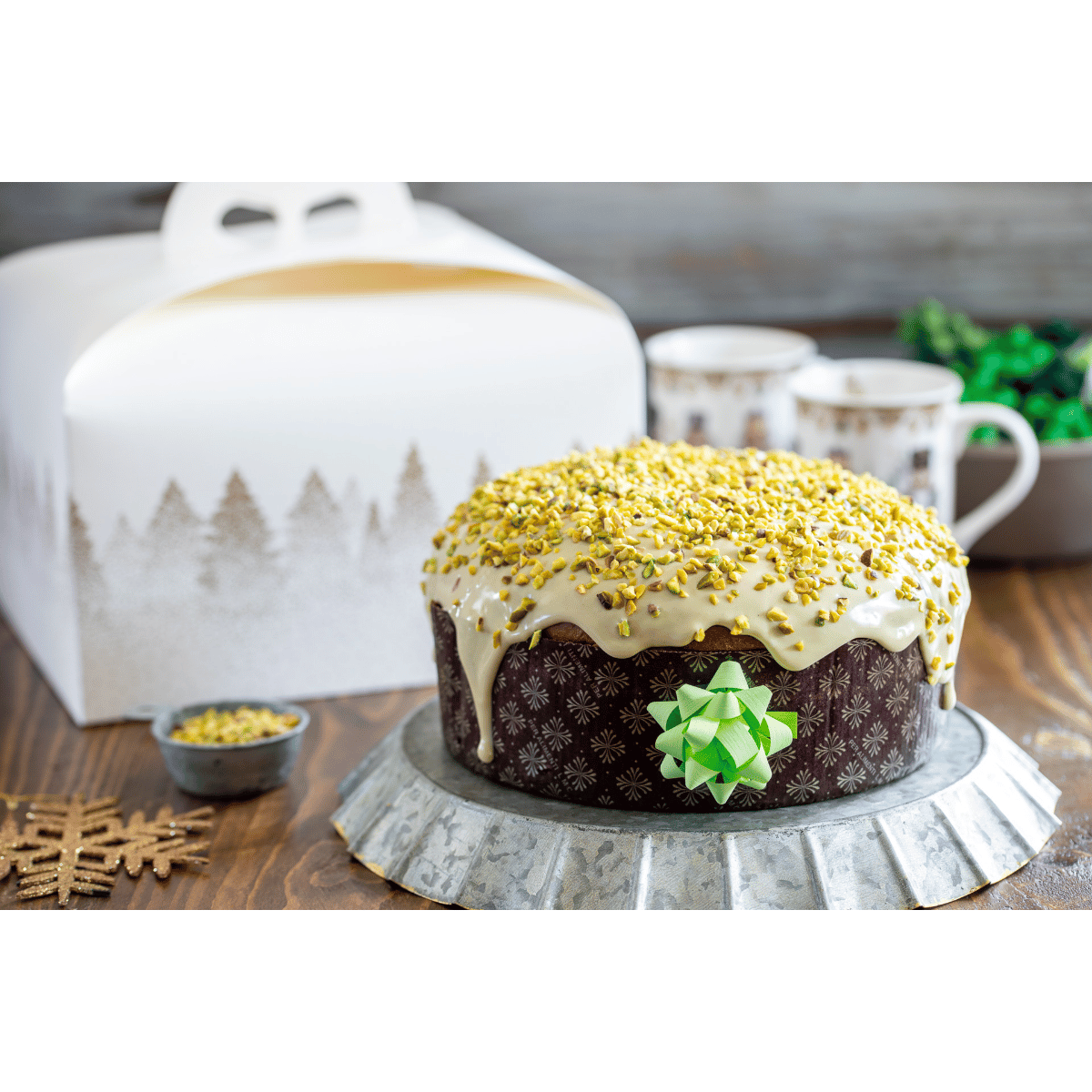 Panettone basso nel suo stampo, su una tavola imbandita 