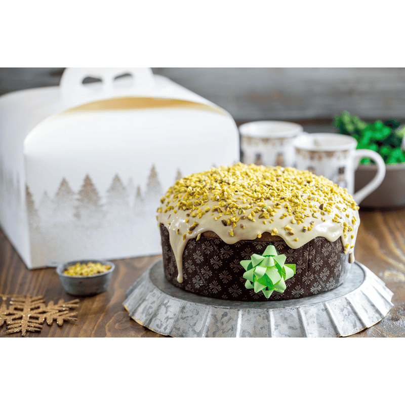 Panettone basso nel suo stampo, su una tavola imbandita 