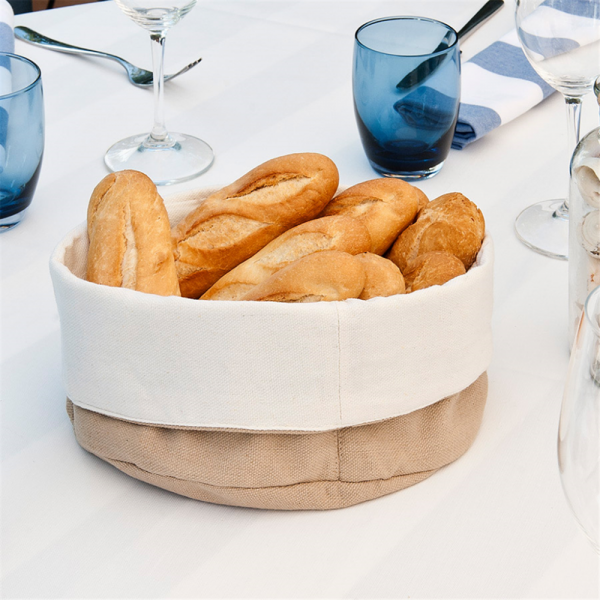 Cesto di stoffa per il pane pieno di pane su una tavola