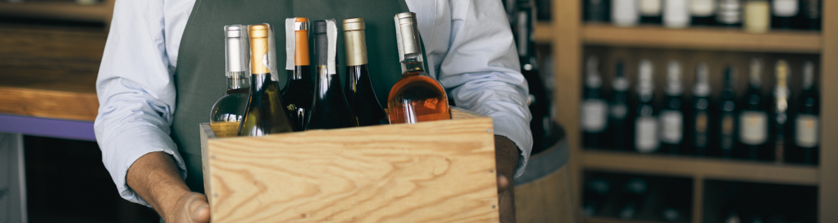 Oste che tiene cassa di legno con dentro vini