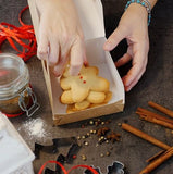 Scatola torta avana aperta con dentro biscotti e mani che li prendono 