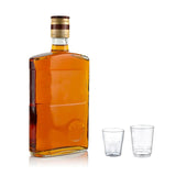 Bottiglia di whisky e due bicchierini da whisky di diversi formati