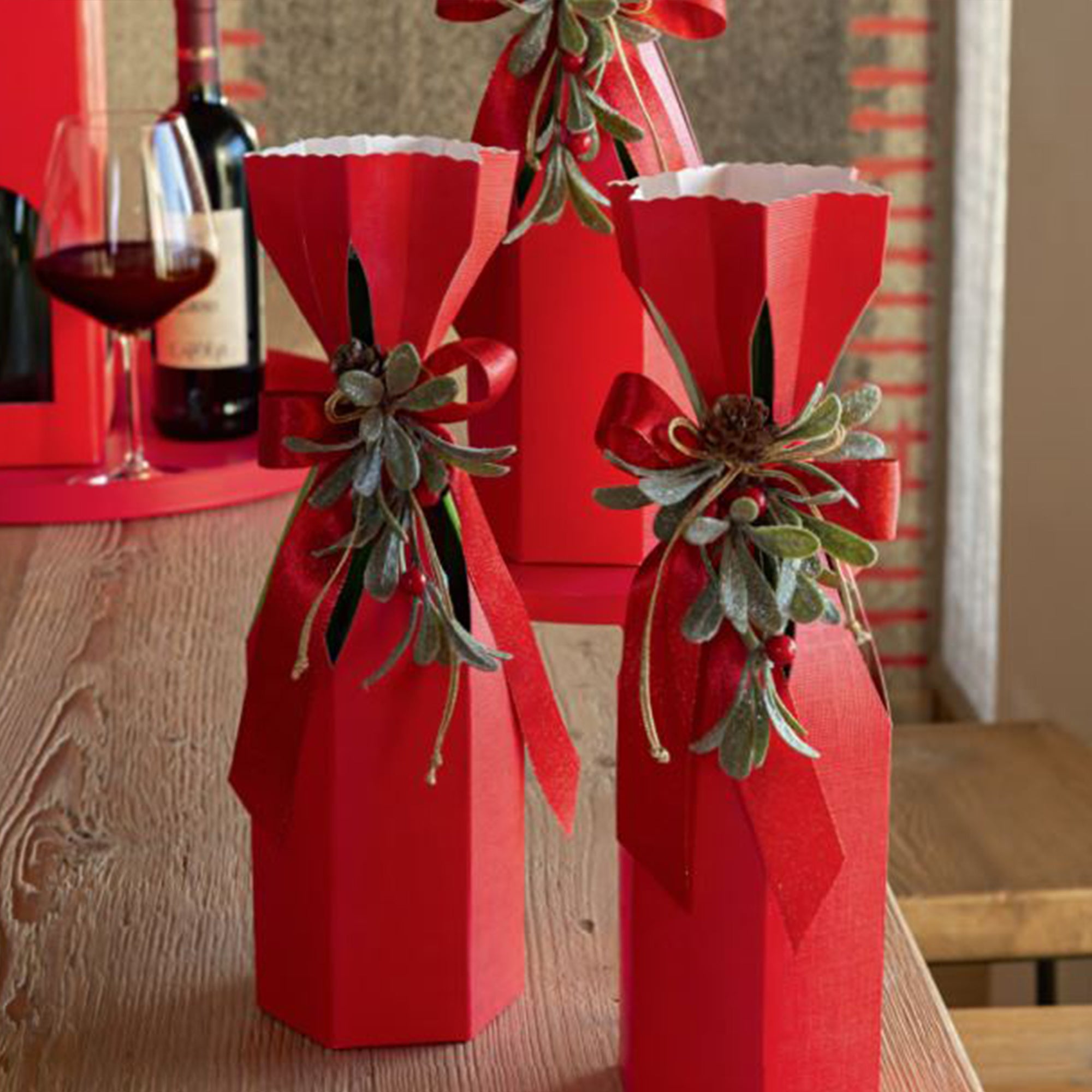 Bottiglie di vino nelle confezioni da una bottiglia, rosse di cartone, su un tavolo 