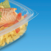 Vaschetta di plastica per cibo, trasparente, chiusa, con insalata di pasta all'interno. Dettaglio si sfondo blu