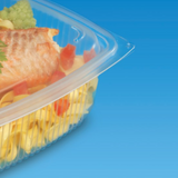 Vaschetta di plastica per cibo, trasparente, chiusa, con insalata di pasta all'interno. Dettaglio si sfondo blu