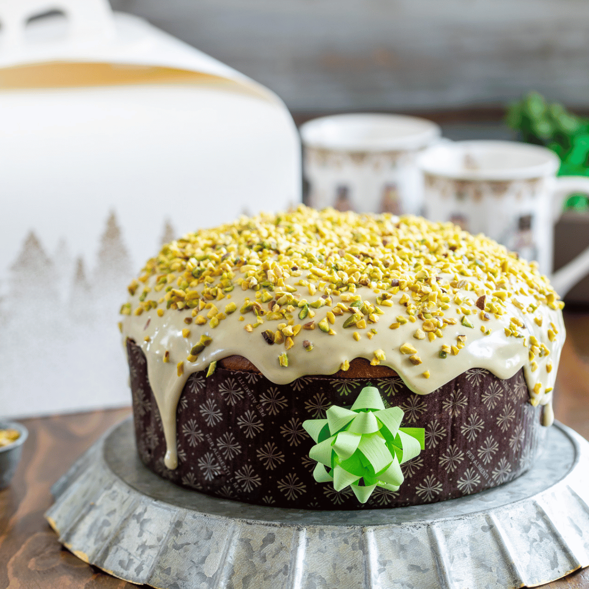 Panettone basso nel suo stampo, su una tavola imbandita 