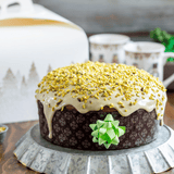 Panettone basso nel suo stampo, su una tavola imbandita 