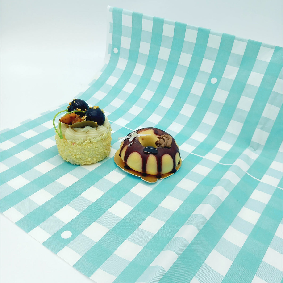 Carta per pasticceria, verde a scacchi, con due dolci