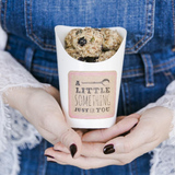 Contenitore bianco di carta per asporto pieno di biscotti retto da due mani