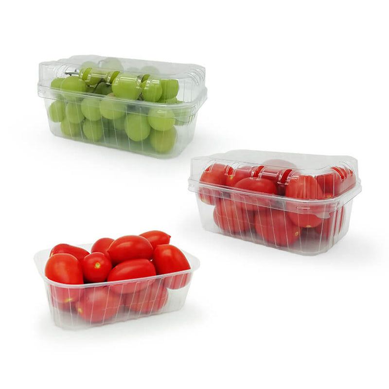 Vaschette trasparenti per frutta e verdura. Una piena di uva e chiusa, una piena di pomodori e chiusa, una piena di pomodori ma senza coperchio