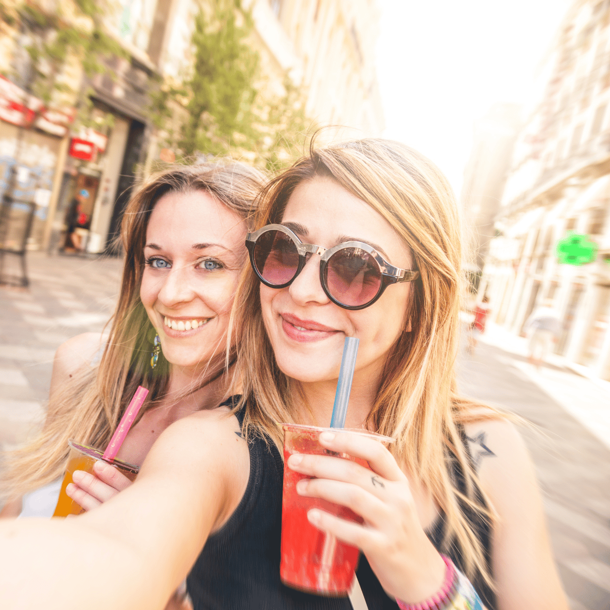 Ragazze che bevono bubble tea con cannucce in una strada cittadina d'estate