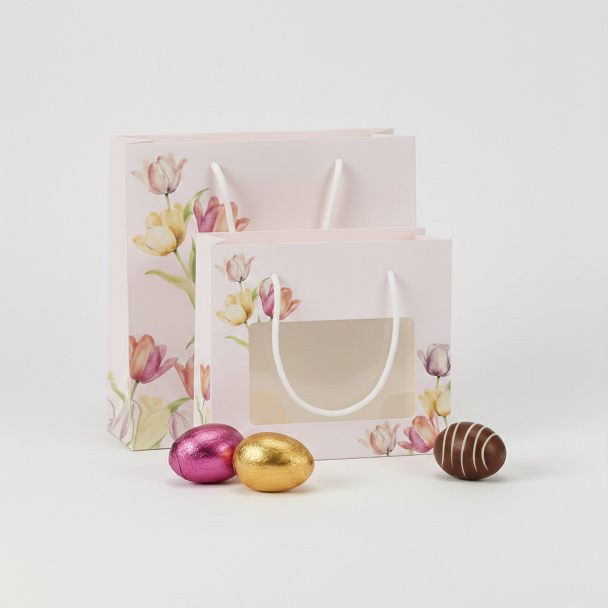 Shopper pasquale di due misure con finestra, aperta, vuota con vicino ovettini di chioccolata 