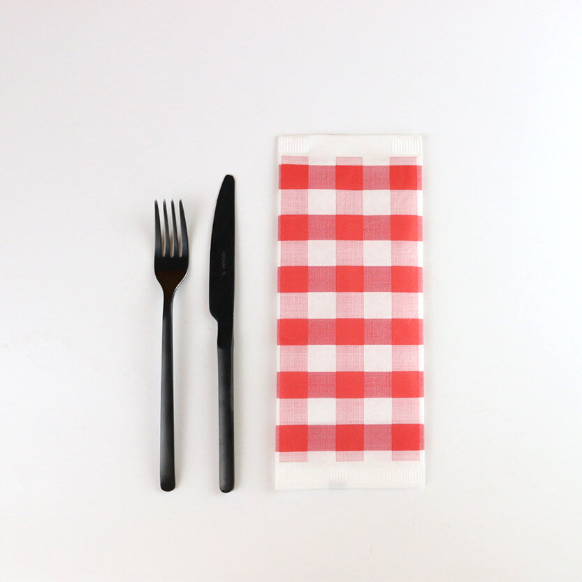 Posate nere vicino a tovagliolo di carta a scacchi bianco rossi