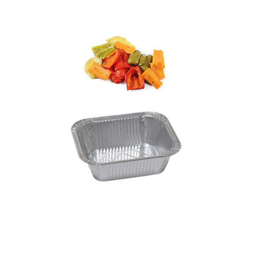 Vaschetta di alluminio vuota con vicino verdure tagliate 