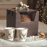 Scatola con finestra porta panettone, con panettone dentro, su vassoio con bicchieri ed elementi natalizi