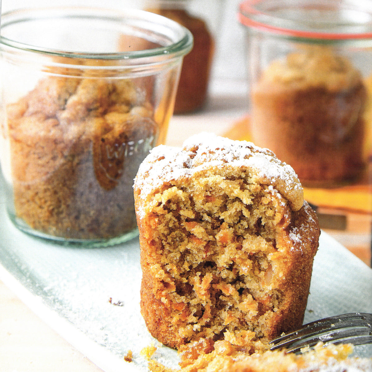 Muffin in primo piano, dietro barattoli pieni 