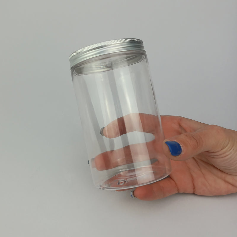 Barattolo trasparenti con tappo color argento tenuto in una mano 