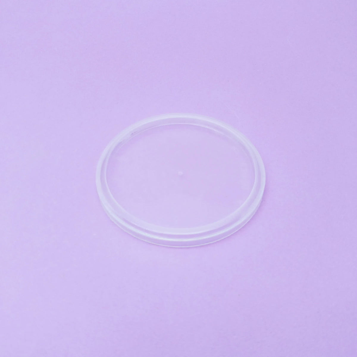 Tappo di plastica per bicchiere, trasparente, su sfondo viola