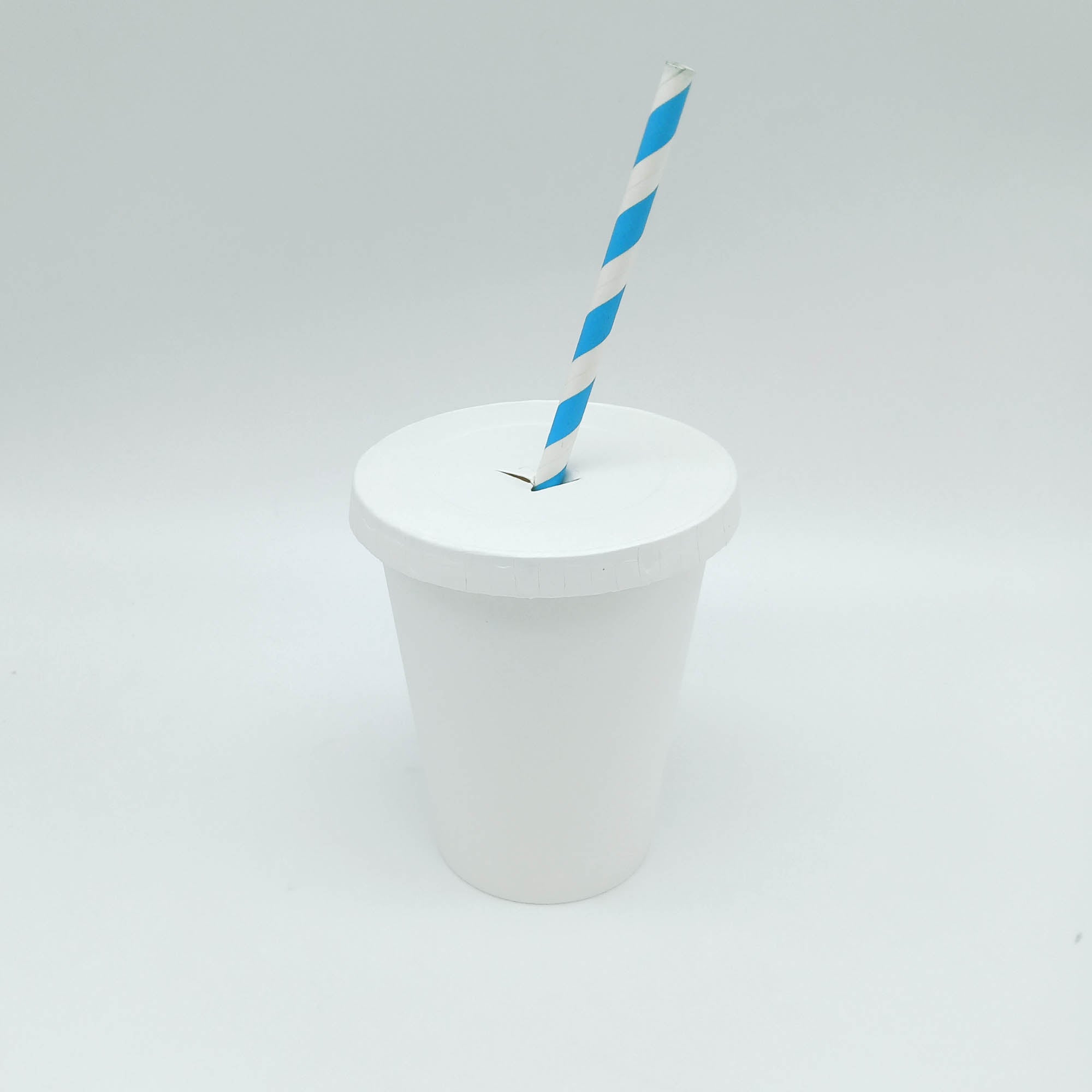 Bicchiere di carta bianco con coperchio con foro con una cannuccia bianca a strisce azzurre 