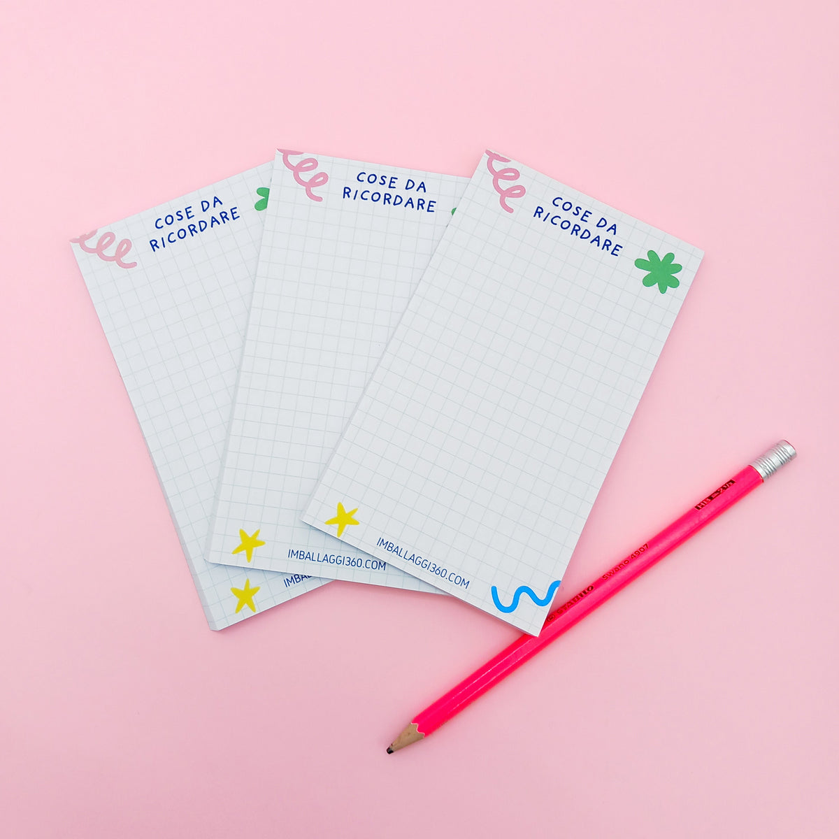 Tre block notes e una matita rosa 