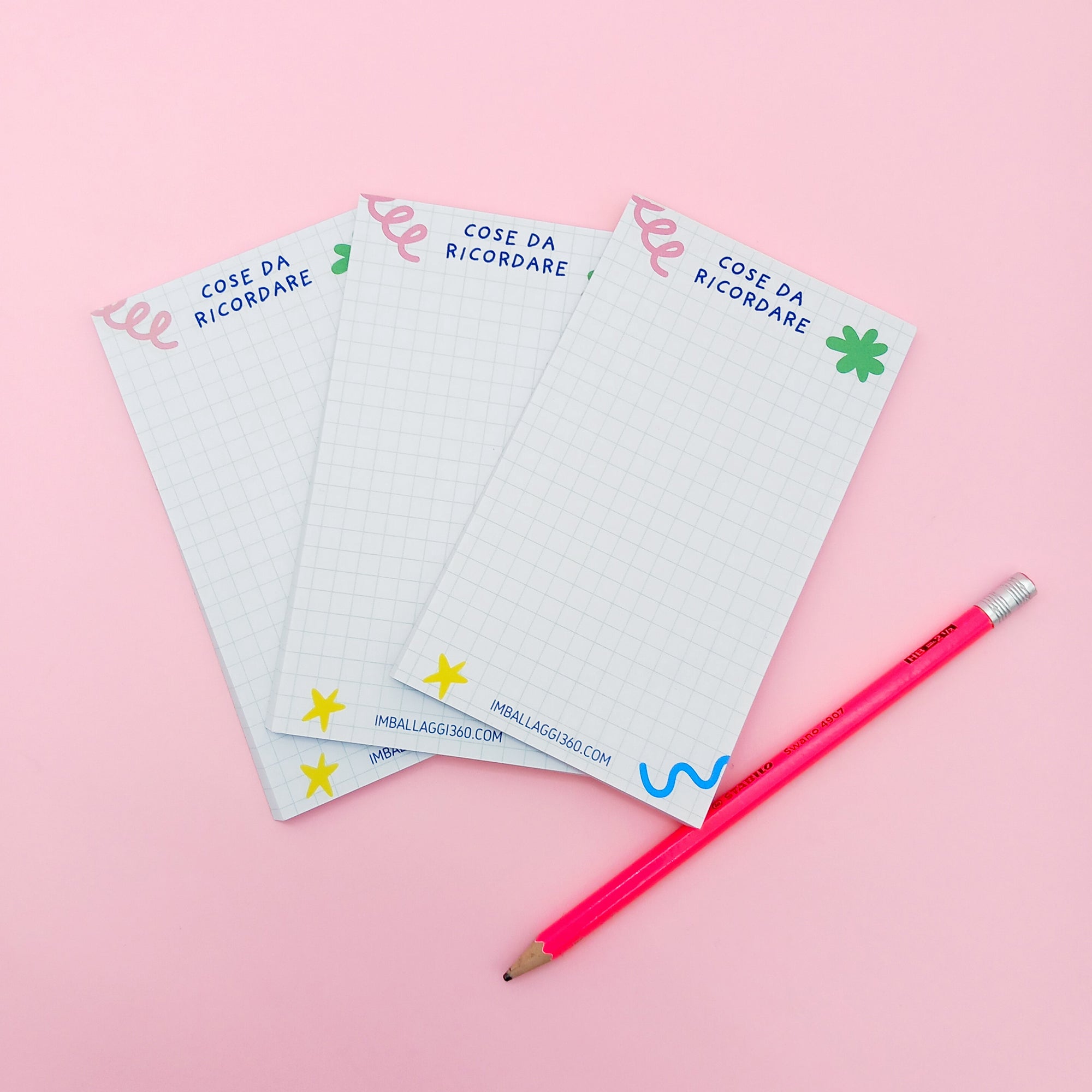 Tre block notes e una matita rosa 