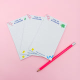 Tre block notes e una matita rosa 