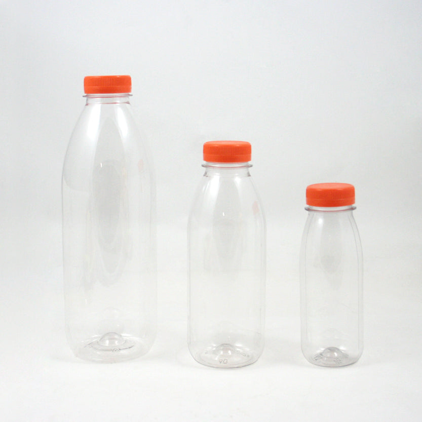 Tre bottiglie di plastica vuote di tre diverse dimensioni con tappo arancione