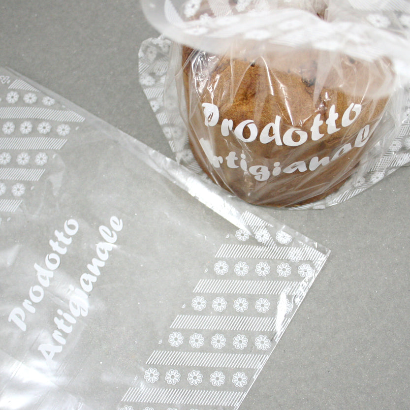 Busta trasparente con scritto PRODOTTO ARTIGIANALE mostrata stesa e ripiena con un mini panettone