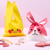 Busta per regalo pasquale a forma di papera e cane, caramelle vicino e sfondo rosa 